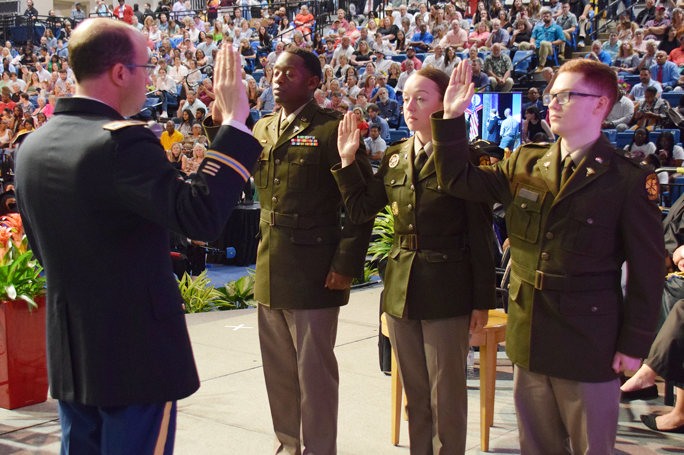 Interim President and Army National Guard Col. John M. Fuchko III administers the oath of office to commissioning cadets at the College of Education & Health Professions commencement ceremony