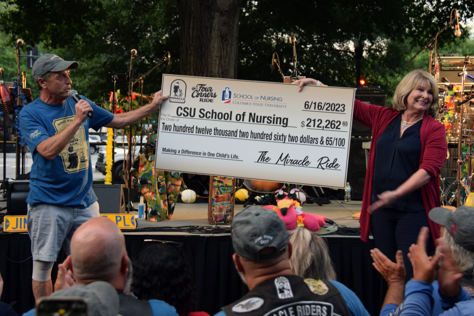 Dr. Rocky Kettering (left) and Dr. Margie Yates (right) present a large check for $212,262.65 from the Miracle Riders