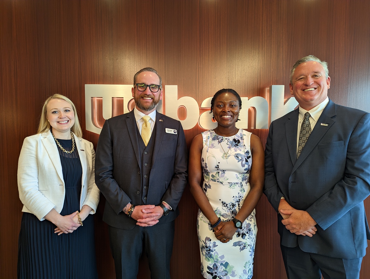 Kiki Patterson with representatives from U.S. Bank standing in front of a sign that reads "US Bank"