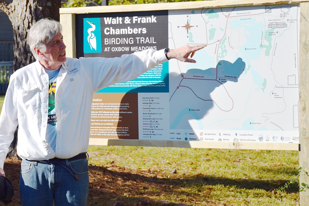 Picture of Michael Dentzau pointing to directional signage for the birding trail