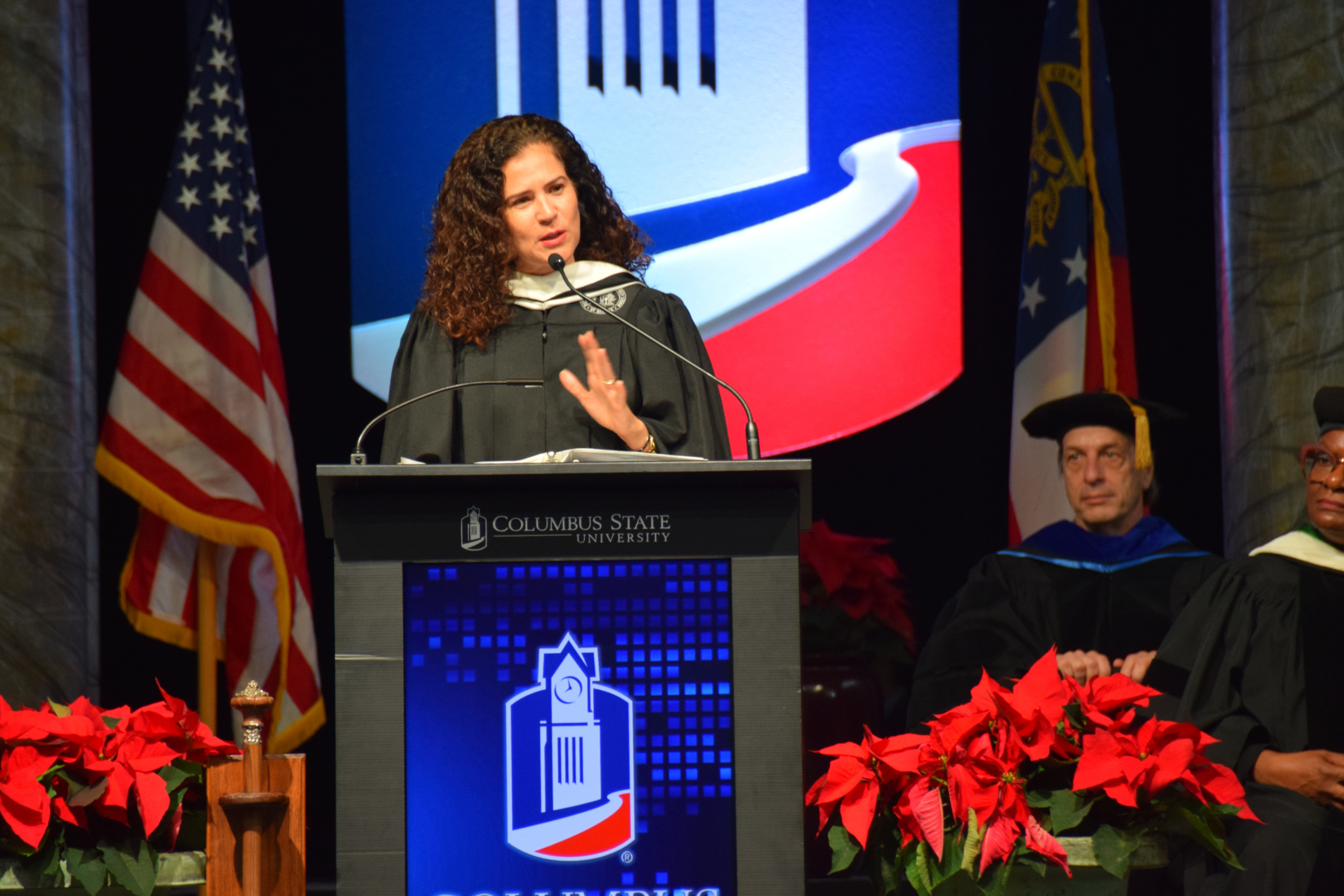 Phot of Barbara Rivera Holmes speaking at a podium at graduation