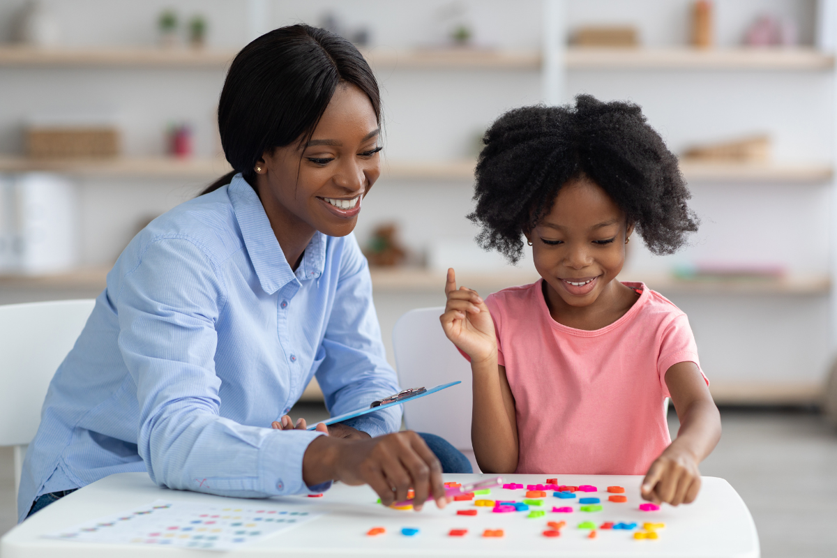 Woman and child working on a learning activity involving colored tiles