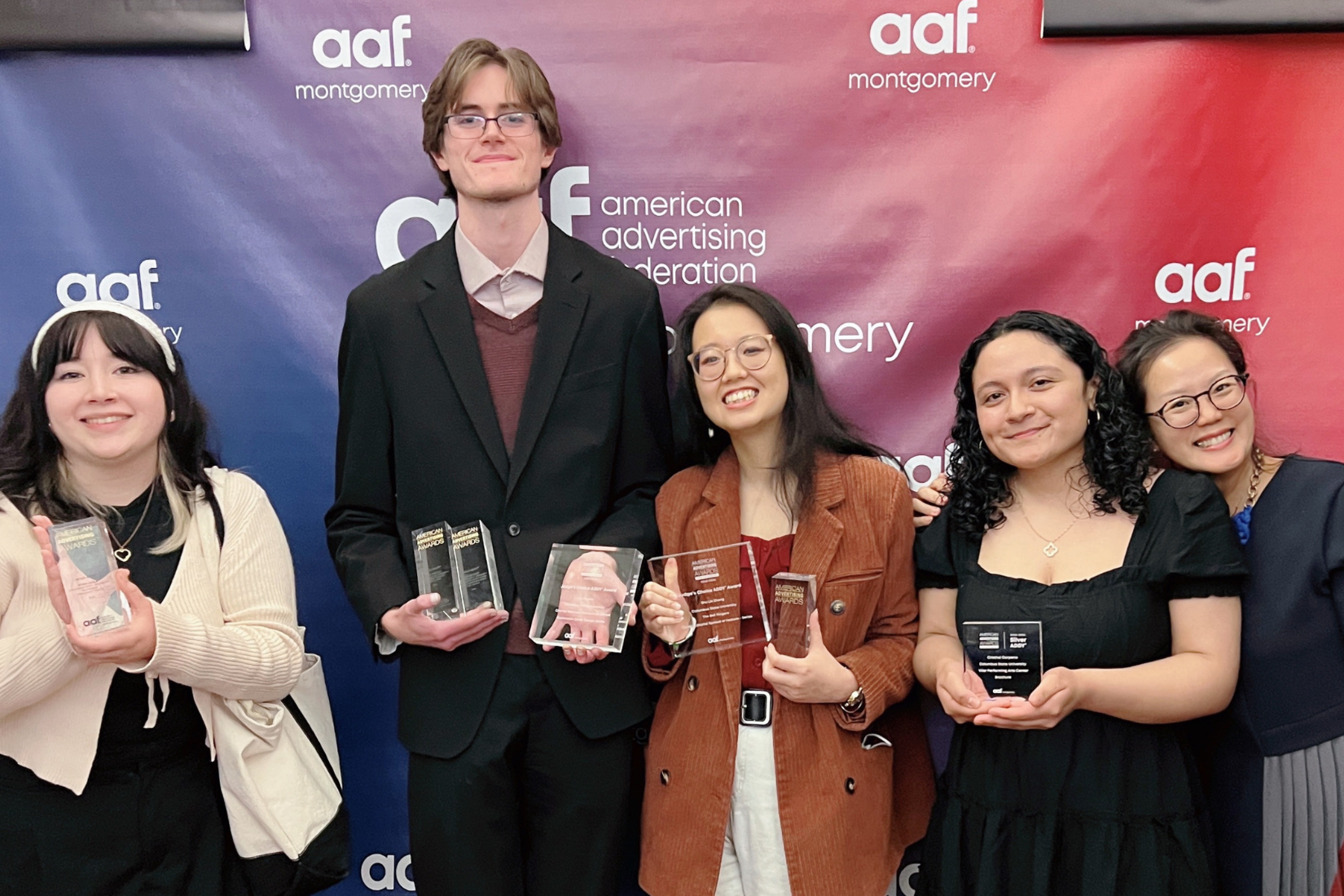 Group of four students holding awards with Assistant Professor Samantha Yoo