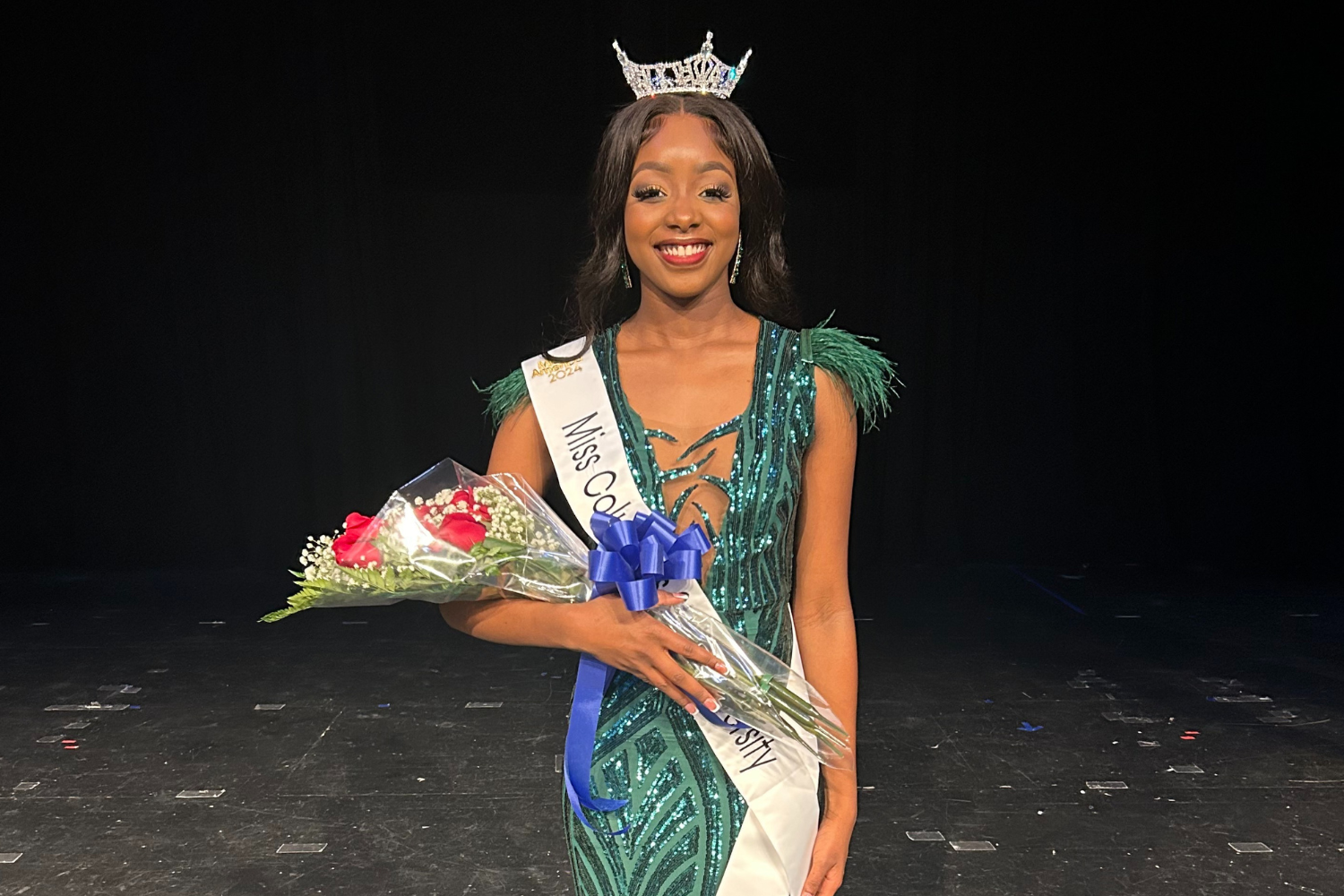 Photo of Kennedy Larkin in a pageant gown wearing a tiara and Miss Columbus State University sash and holding a bouquet of flowers