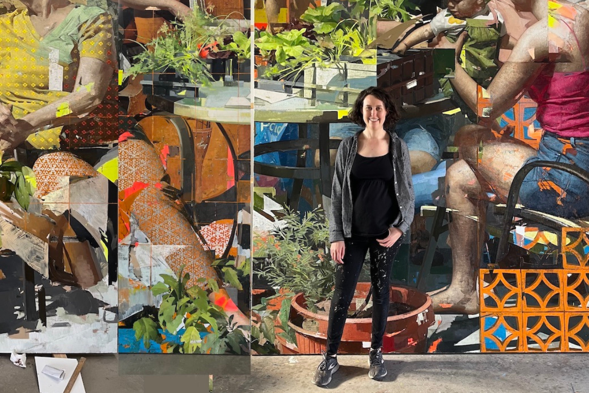 Zoey Frank standing in front of a portion of her painting