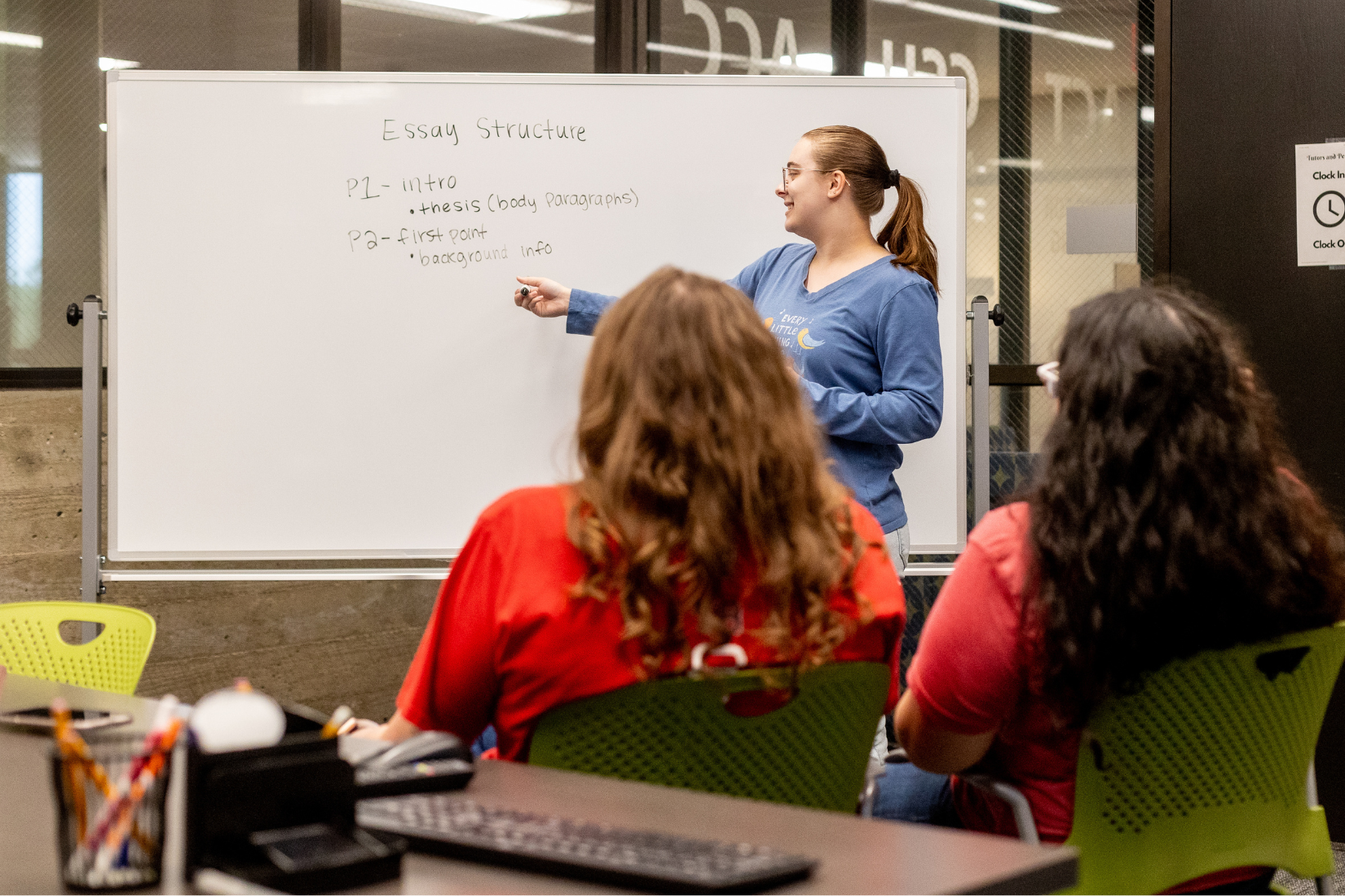 A student in front of a whiteboard presenting information to other students