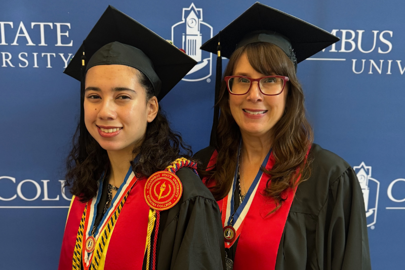 Ari and Ami Poveda dressed in graduation attire.