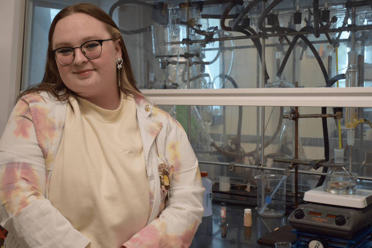 Presley Simmons standing in front of a laboratory fume hood