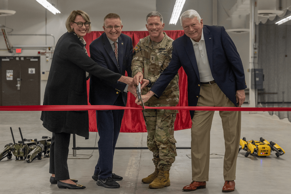 A picture of four people cutting a grand-opening ribbon
