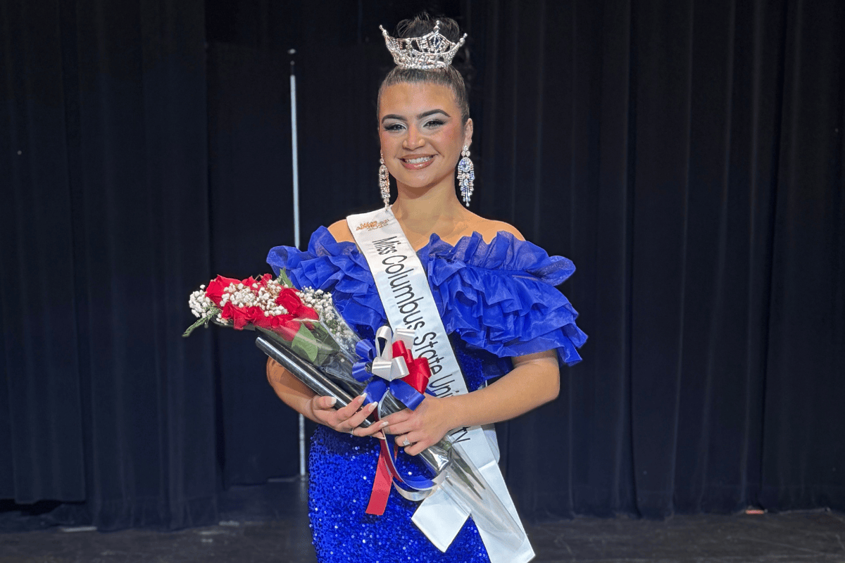 Pageant photo of Miss CSU Valeria Saer wearing her tiara and sash and holding flowers