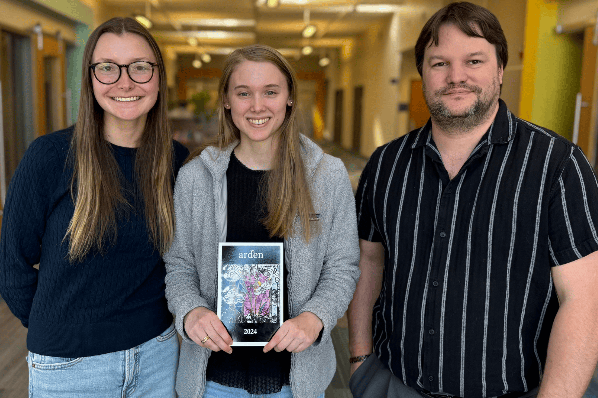 Photo of Maddie Ginter, Elizabeth Woods (holding a copy of The Arden) and Zachary Lamb.