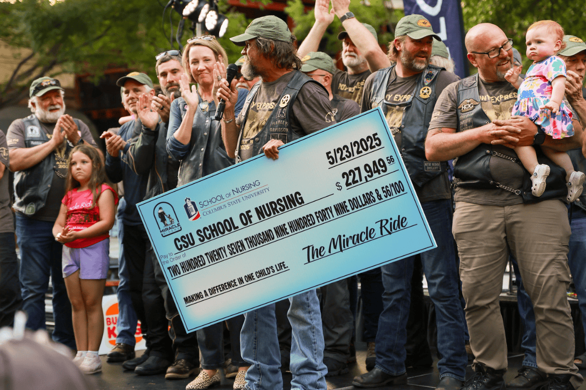 Scott Ressmeyer holding a ceremonial check to the CSU School of Nursing for $227.949