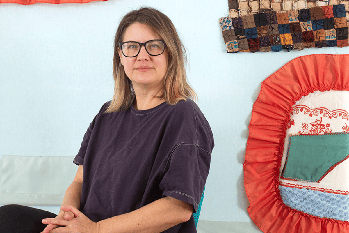 Coulter Fussell sitting among her quilted artwork; photo courtesy of Coulter Fussell