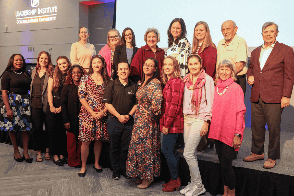 A group photo of current and past leaders, staff and affiliates of the Leadership Institute on a stage at the organization's 20th anniversary luncheon