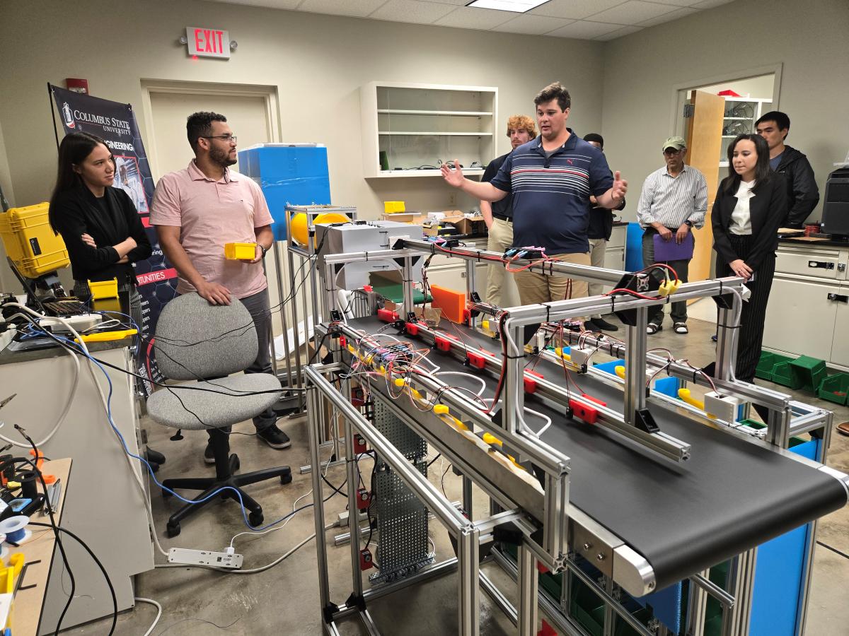 Nickerson previews the automated sorter prototype for classmates and Pratt & Whitney representatives in the Robotics Engineering lab.