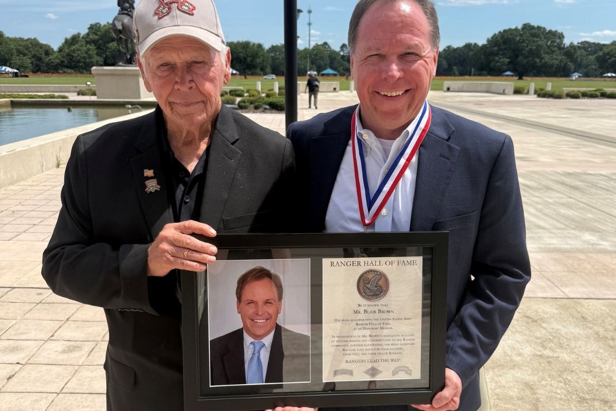 Blair Brown smiles alongside his father Roger Brown as they hold his framed certificate following his induction as an honorary member into the U.S. Army Ranger Hall of Fame.