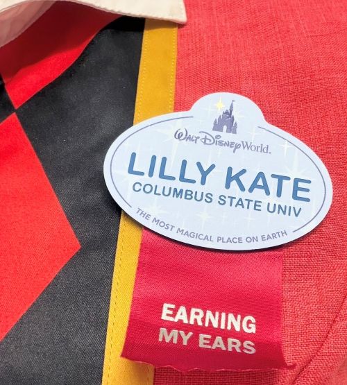 Close-up of a Disney College Program name tag for Columbus State University student Lilly Kate, featuring a red "Earning My Ears" ribbon.